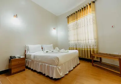 a bedroom with a large white bed and a window at Panama Garden Resort in Moshi