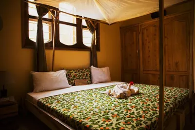 a bedroom with a canopy bed with a stuffed animal on it at More Than A Drop in Moshi