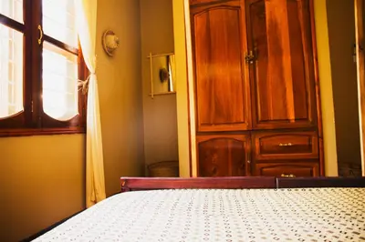 a bedroom with a bed and a wooden door at More Than A Drop in Moshi