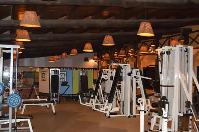 a gym with lots of machines and pendant lights at Ameg Lodge Kilimanjaro in Moshi