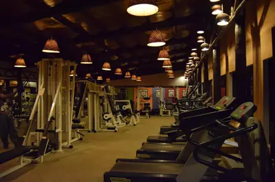 a gym with rows of tread machines and lights at Ameg Lodge Kilimanjaro in Moshi