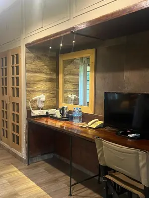 a room with a desk with a phone and a mirror at Ameg Lodge Kilimanjaro in Moshi