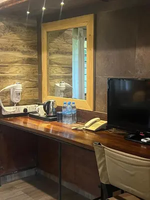 a reception desk with a television and a mirror at Ameg Lodge Kilimanjaro in Moshi