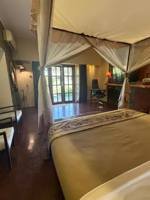 a bedroom with a large bed with a canopy at Ameg Lodge Kilimanjaro in Moshi