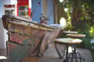 an old rusty bench with a table and a stool at Boulevard Inn Mt Meru in Arusha