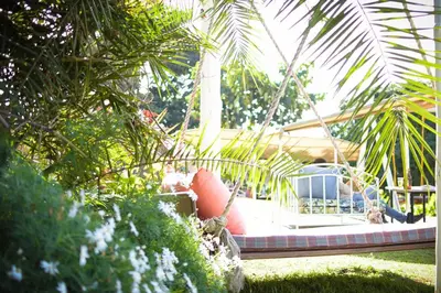 a swing in a garden with a house at Boulevard Inn Mt Meru in Arusha