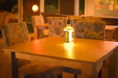 a bottle of alcohol sitting on top of a wooden table at Boulevard Inn Mt Meru in Arusha