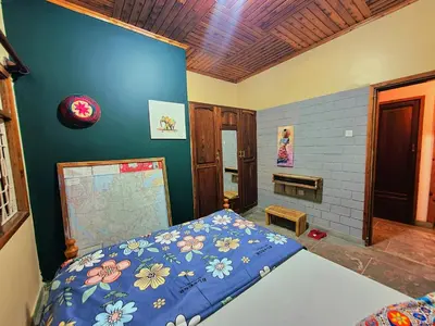 a bedroom with a bed and a blue wall at Mazzola Safari House & Backpacking in Arusha