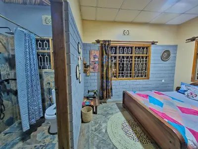 a bedroom with a bed and a toilet in it at Mazzola Safari House & Backpacking in Arusha