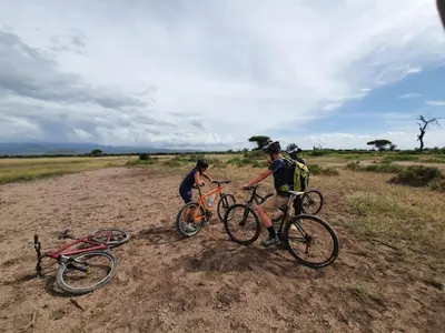 three people on bikes on a dirt road at Mazzola Safari House & Backpacking in Arusha