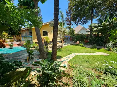 a house with a garden and a walkway at Mazzola Safari House & Backpacking in Arusha