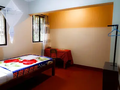 a small bedroom with a bed and a table at Endasawa Tree Lodge in Usa River