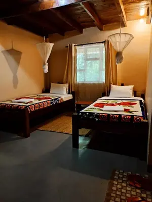 a bedroom with two beds and a window at Endasawa Tree Lodge in Usa River