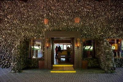 a building with a stone wall with a doorway at Ngorongoro Serena Safari Lodge in Ngorongoro