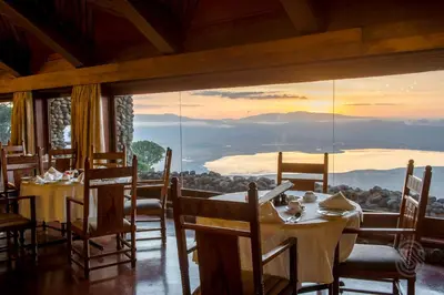 a dining room with a table and a large window at Ngorongoro Serena Safari Lodge in Ngorongoro