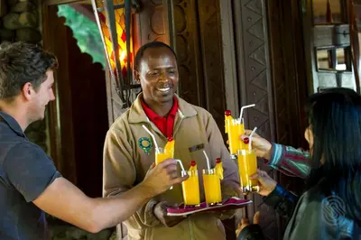 a man holding up a tray of lit candles at Ngorongoro Serena Safari Lodge in Ngorongoro