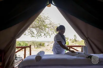 a woman standing inside of a tent at Mbuzi Mawe Serena Camp in Serengeti