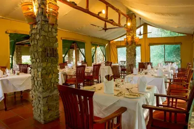 a dining room with white tables and chairs at Mbuzi Mawe Serena Camp in Serengeti