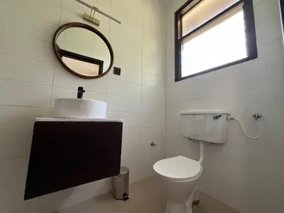 a bathroom with a toilet and a mirror at Bristol Cottages Kilimanjaro in Moshi