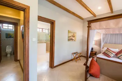 a bedroom with a bed and a bathroom at Airport Planet Lodge in Kingori