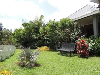 a bench sitting on the grass in a garden at Airport Planet Lodge in Kingori
