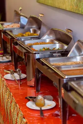 a row of trays filled with food on a table at Airport Planet Lodge in Kingori