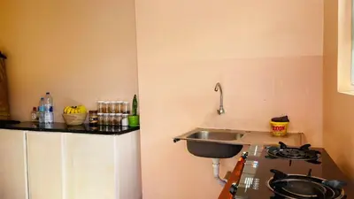 a small kitchen with a sink and a stove at Maasai Hostel Tanzania in Arusha
