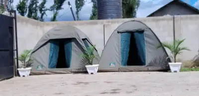 two tents are set up next to a fence at Maasai Hostel Tanzania in Arusha