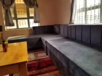 a living room with leather couches and a table at Maasai Hostel Tanzania in Arusha