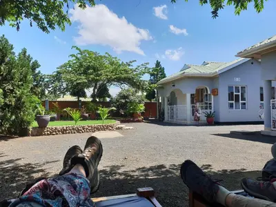 a person laying on a bench in front of a house at Le Parlour in Boma la Ngombe
