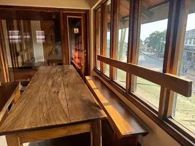 a wooden bench sitting in front of a window at Arusha Backpackers Hotel in Arusha