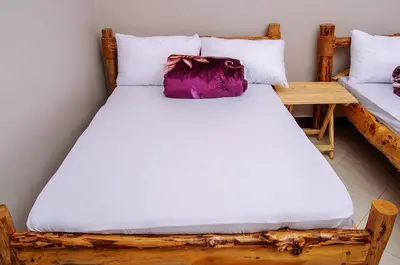 a bed with a wooden frame and a pillow on it at Wanyama B&B in Arusha