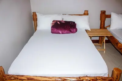a bed with a purple bag sitting on top of it at Wanyama B&B in Arusha