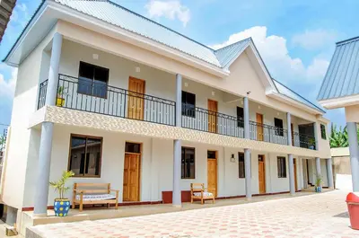 a large white house with a balcony at Wanyama B&B in Arusha