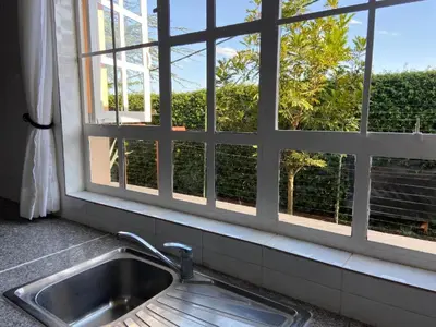 a kitchen sink in front of a window at Daria Apartment -Burka -3 minutes from Arusha Airport in Arusha