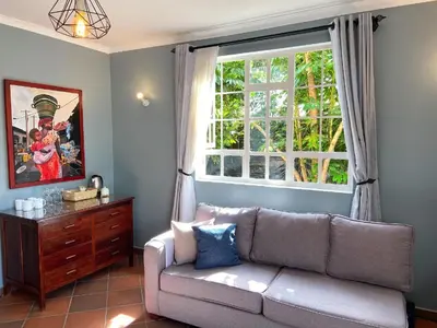 a living room with a couch and a window at Daria Apartment -Burka -3 minutes from Arusha Airport in Arusha