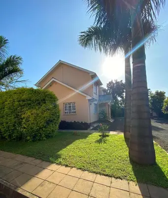 a palm tree in front of a house at Daria Apartment -Burka -3 minutes from Arusha Airport in Arusha