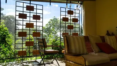 a living room with a couch and a large window at Arusha Villa Karamu Coffee Estate in Usa River