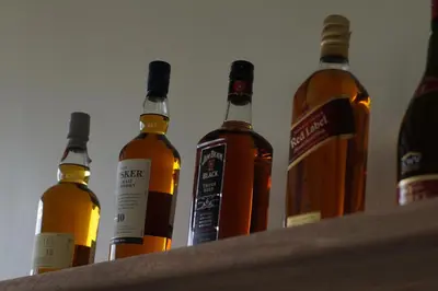 a group of bottles of alcohol sitting on a shelf at Arusha Villa Karamu Coffee Estate in Usa River