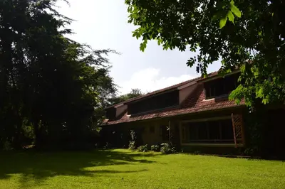 a house with a grass yard in front of it at The Researchers Rest in Arusha