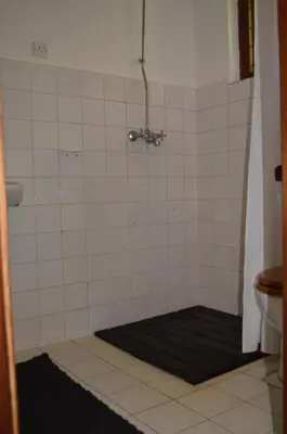 a shower with a black mat in a bathroom at The Researchers Rest in Arusha