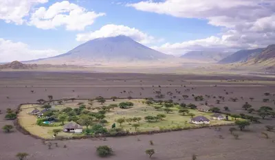 an island in the middle of a desert with a mountain at Lake Natron Maasai giraffe eco Lodge and camping in Mtowabaga