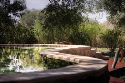a pool of water with a path around it at Lake Natron Maasai giraffe eco Lodge and camping in Mtowabaga