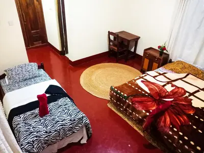 a room with two beds in a room with arero at Shimbwe Meadows Home in Moshi