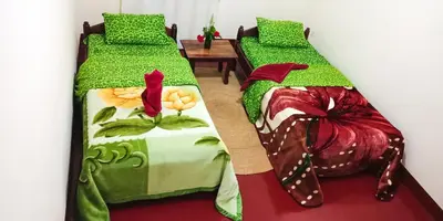 two beds sitting next to each other in a room at Shimbwe Meadows Home in Moshi
