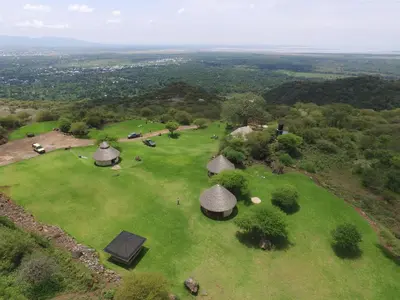 an overhead view of a green field with tents on it at Migombani Camp in Mto wa Mbu