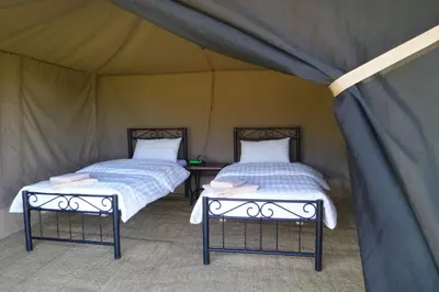 two beds sitting inside of a tent at Migombani Camp in Mto wa Mbu