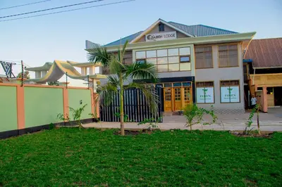 a house with a palm tree in front of it at Jaden Hotel & Lounge - Arusha in Arusha
