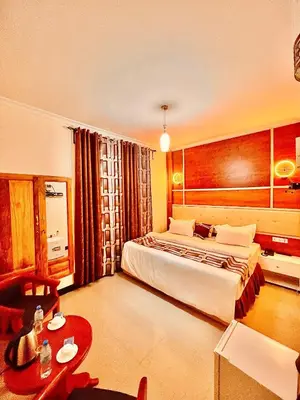a hotel room with a bed and a table at Jaden Hotel & Lounge - Arusha in Arusha