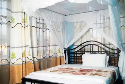 a bedroom with a canopy bed with curtains at Jaden Hotel & Lounge - Arusha in Arusha